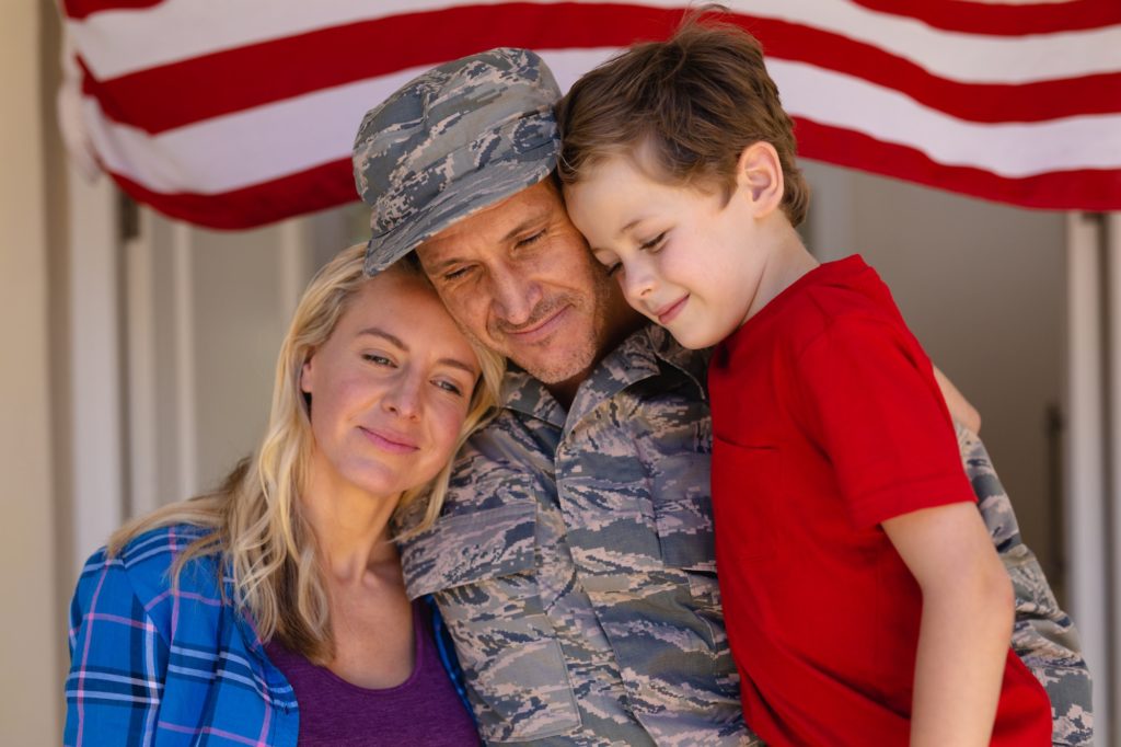 Caucasian family with military man standing entrance of house